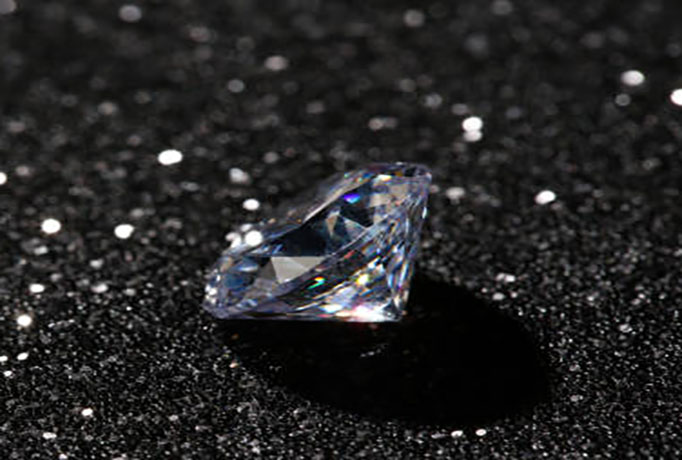 Beautiful dazzling diamond on dark shiny background. Space for text